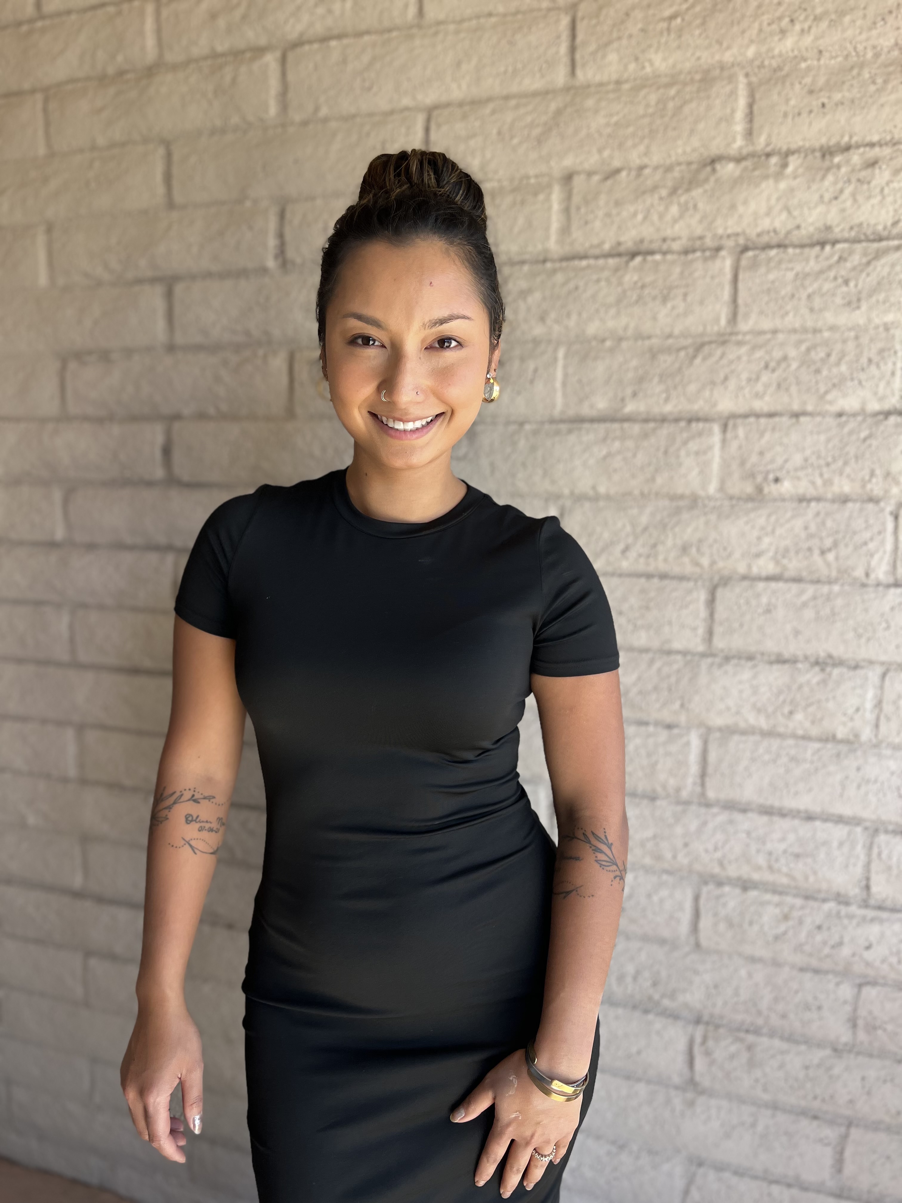 Woman standing against a white brick wall